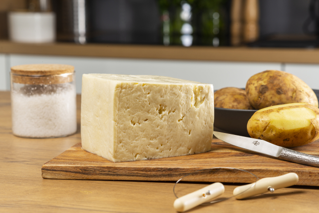 Tome fraîche de l'Aubrac sur un plateau avec des pommes de terre